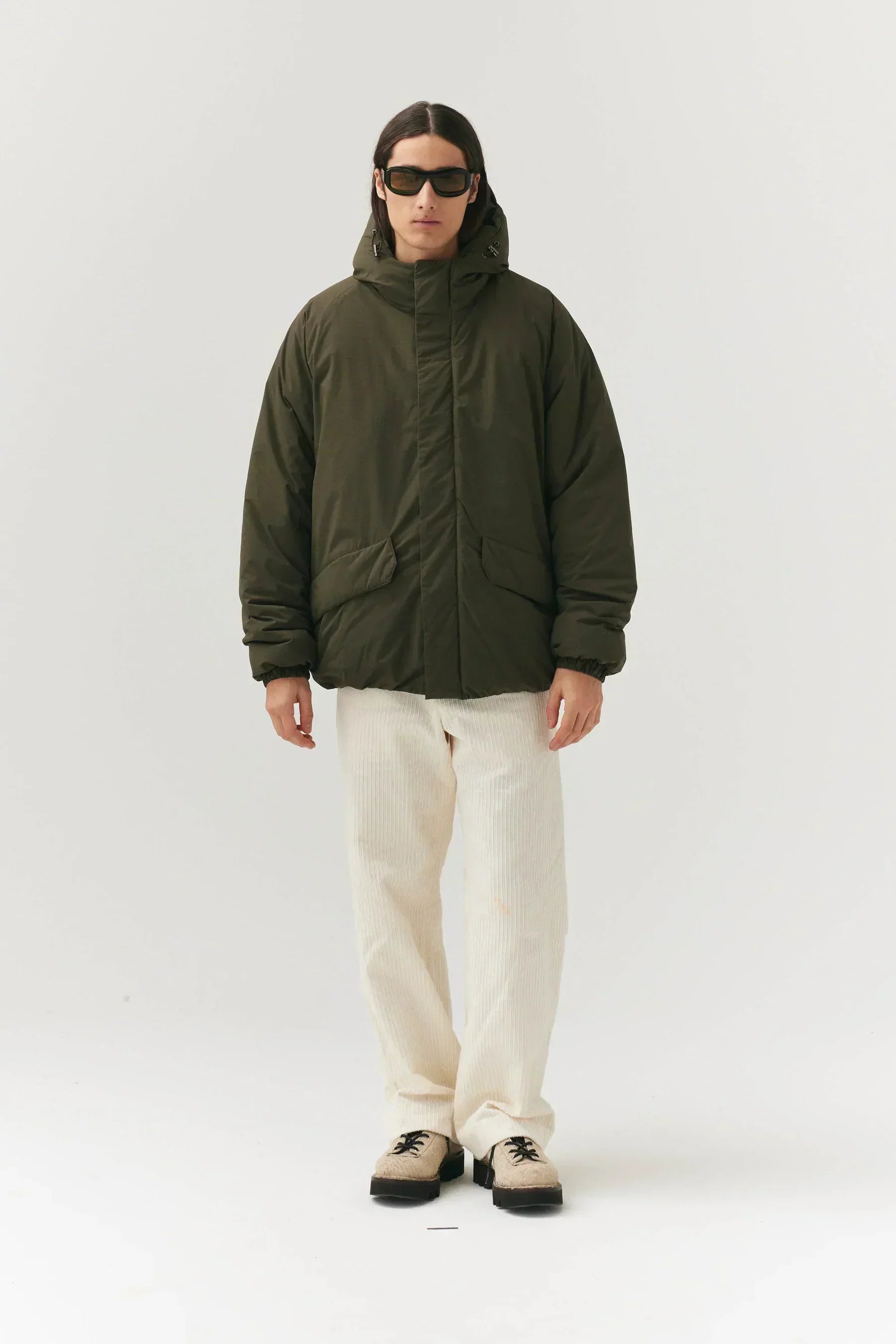 Prestige Market K-SEA New Army Jacket displayed on a hanger, featuring a rugged military style with multiple pockets and durable fabric.